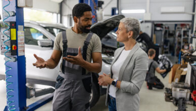 client seeks clarification from mechanic in garage